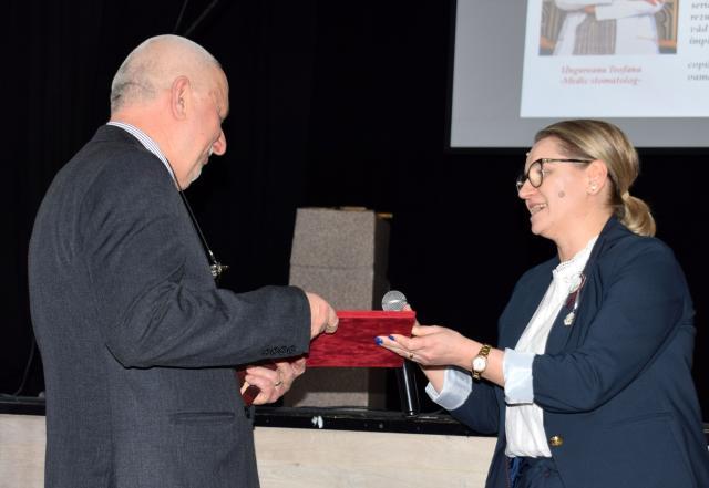 Prof. Brânduşa Nisioi, directoarea Școlii Gimnaziale „Alexandru Ioan Cuza”, oferă diploma de recunoștință