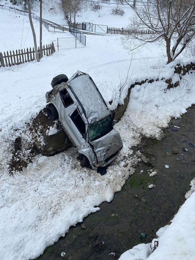 O mașină a ajuns în albia unui pârâu după ce a derapat pe șoseaua umedă