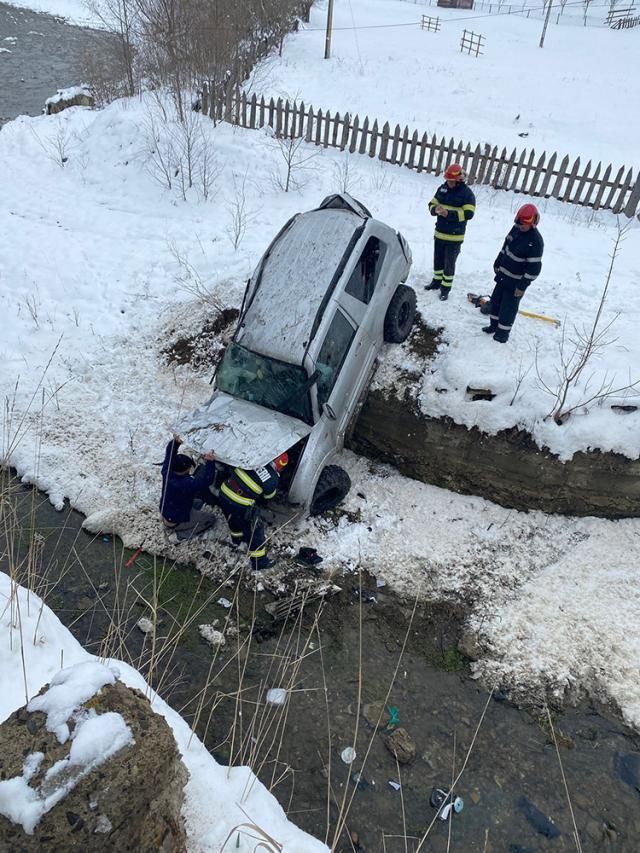 O mașină a ajuns în albia unui pârâu după ce a derapat pe șoseaua umedă