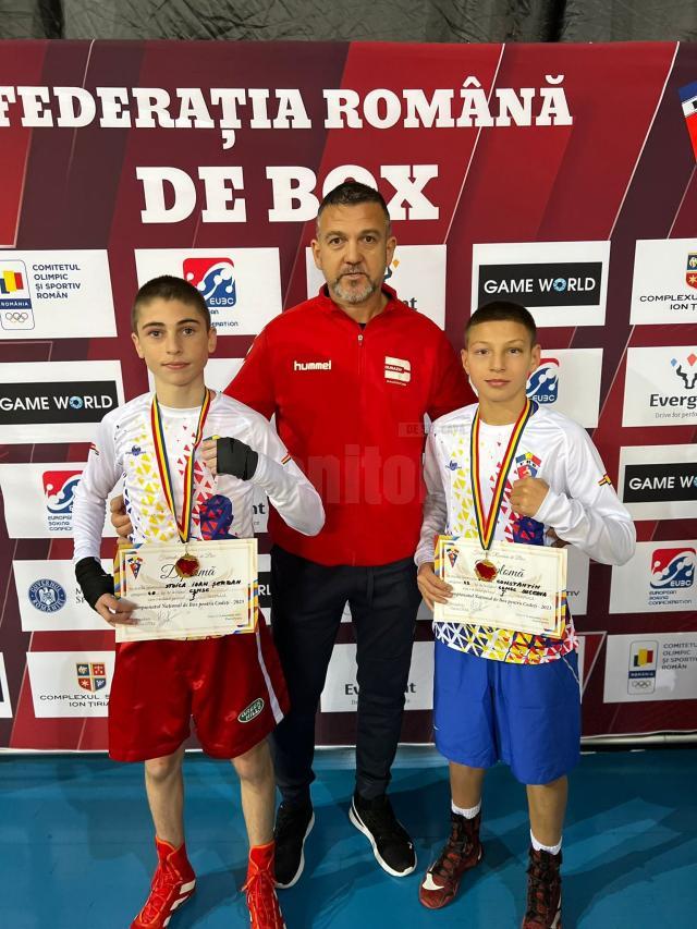 Antrenorul Andu Vornicu încadrat de cei doi tineri campioni