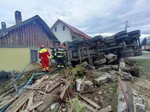 O autobasculantă s-a răsturnat peste garduri și două locuințe