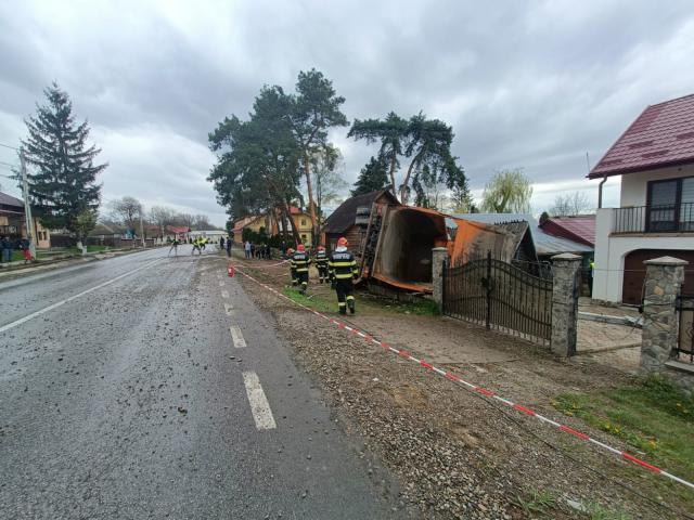 O autobasculantă s-a răsturnat peste garduri și două locuințe