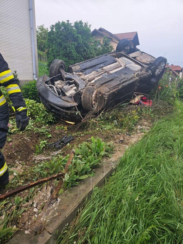 O șoferiță însărcinată s-a răsturnat cu mașina în curtea unei case