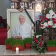 Imaginea Papei Francisc cu o panglică neagră și o candelă aprinsă, lângă lumânarea ...