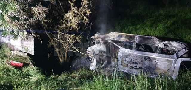 O mașină care a lovit un cap de pod s-a răsturnat și a luat foc