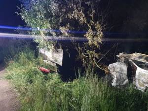 O mașină care a lovit un cap de pod s-a răsturnat și a luat foc