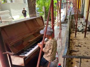 Minirecital susținut printre schele, de către un copil de 7 ani, la o pianină abandonată