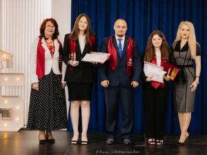 Cele doua eleve alaturi de directorul Adrian Puiu si cadre didactice