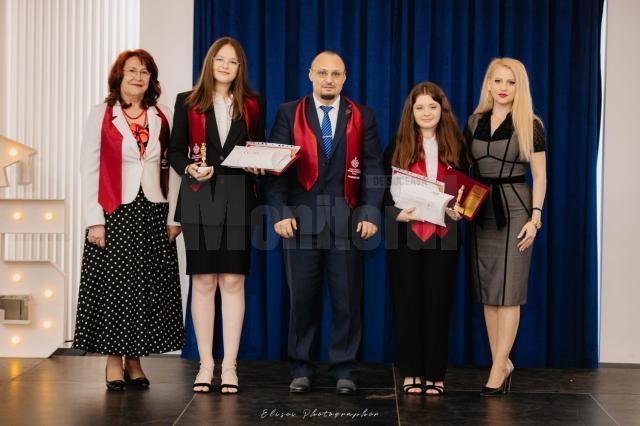 Cele două eleve alături de directorul Adrian Puiu şi cadre didactice