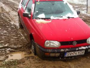 Drum desfundat şi o maşină înţepenită într-o groapă, în cartierul de vile dintre Burdujeni şi Iţcani